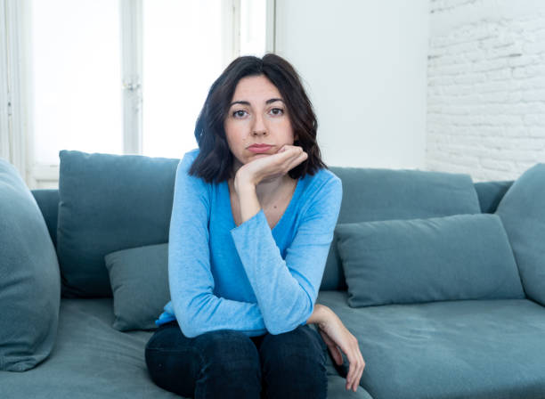 istock Young upset woman on sofa using control remote zapping bored of bad TV shows and programing . Looking disinterested, aloof and sleepless. People, too much bad television and Sedentary lifestyle. 1164367511