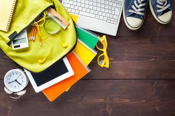 School backpack and school supplies on wooden background