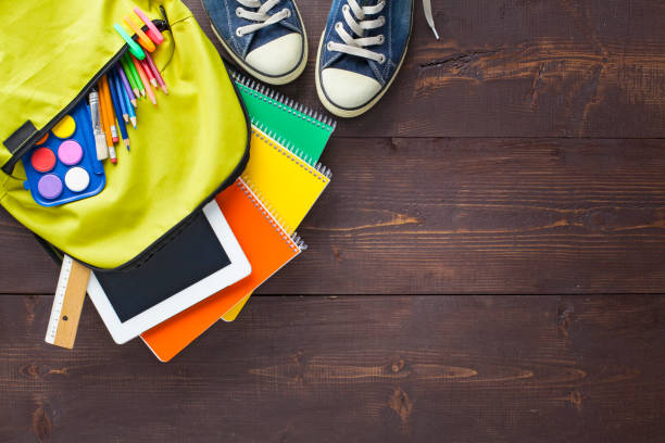 istock School backpack and school supplies on wooden background 1164369091
