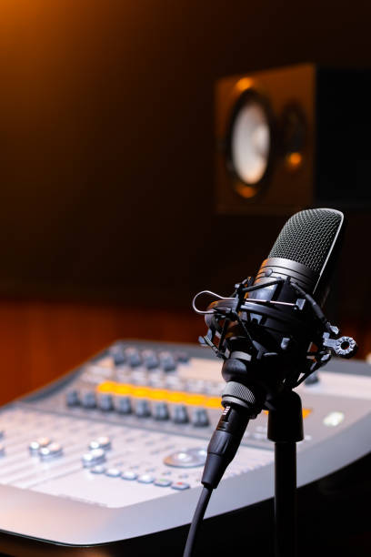 istock microphone on mixing console and loudspeaker monitor background. recording concept 1164370788