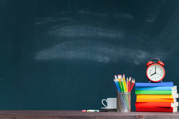 istock Alarm clock on books on school teacher's desk 1164371091