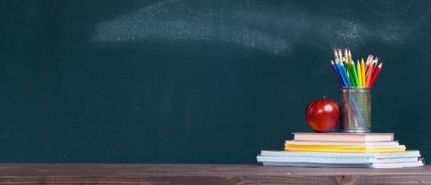 карандашный поднос и яблоко на тетрадях на столе школьного учителя - back to school blackboard education apple стоковые фото и изображения