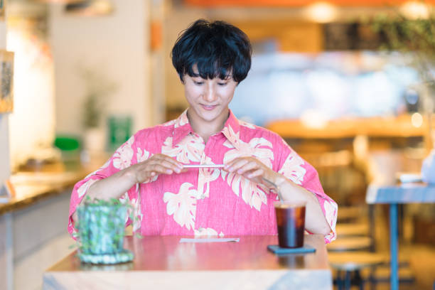 Modern man doing e-banking in cafe A millennial modern man is doing electronic bookkeeping on a laptop in a cafe. He is doing e-banking in a cafe. japan restaurant bill stock pictures, royalty-free photos & images