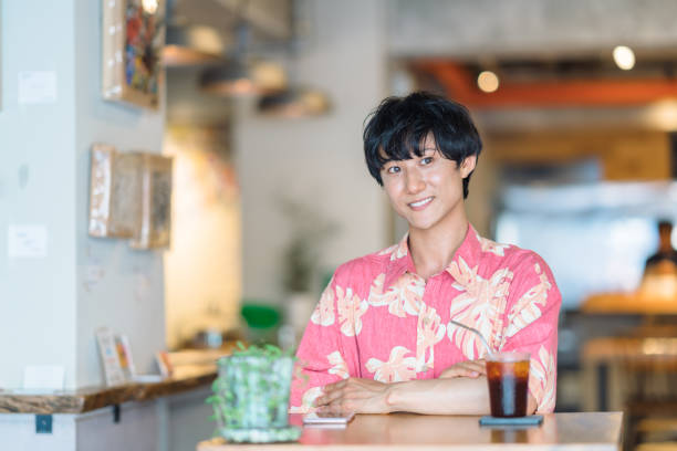 Modern man doing e-banking in cafe A millennial modern man is doing electronic bookkeeping on a laptop in a cafe. He is doing e-banking in a cafe. japan restaurant bill stock pictures, royalty-free photos & images