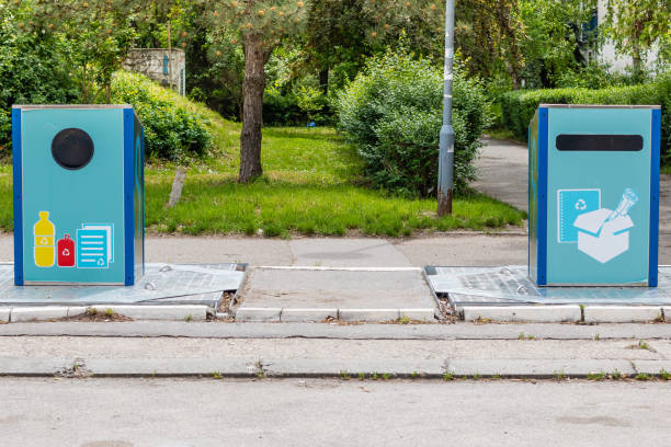 istock Two blue recycle bins with recycle symbol for various type of garbage, plastic, cans and paper, on the sidewalk. 1164372276