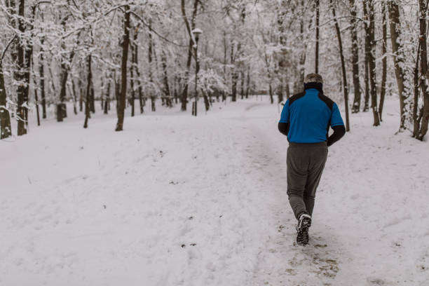 istock Senior man jogging in snow 1164376243