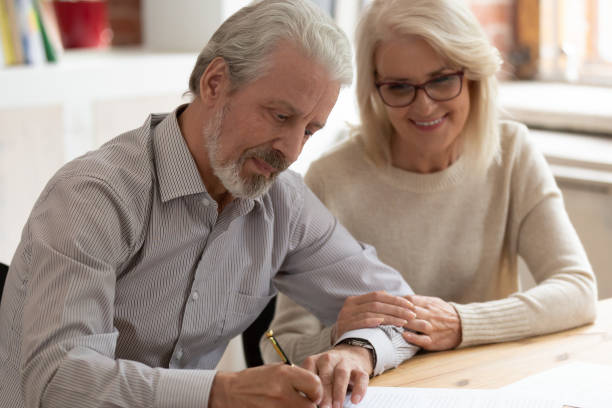 o marido e a esposa dos pares da família mais idosa feliz assinam o papel - retirement occupation sign planning - fotografias e filmes do acervo