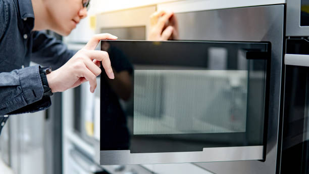 istock Asian man opening microwave door 1164381973