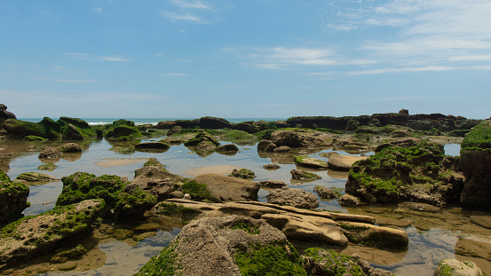 View of the Las Pocitas sector on the beach of Mancora on blue sky with clouds in the background. Peru