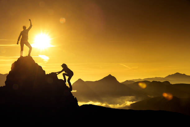 istock Two women climbing on a mountain peak 1164383030