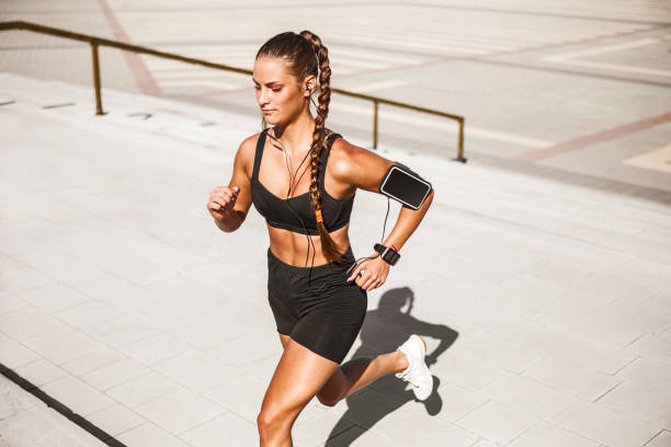 istock Young sportswoman running up stairs 1164386161