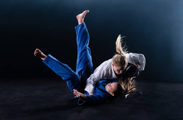 istock Female Judoka Throwing Her Partner To The Ground 1164387300