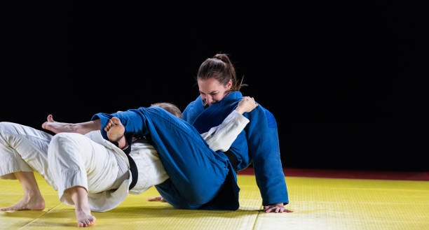 istock Female Judoka Choking Her Sparring Partner With Her Legs 1164387301