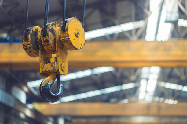 yellow crane hook for overhead crane in hangar warehouse - pulley hook crane construction imagens e fotografias de stock