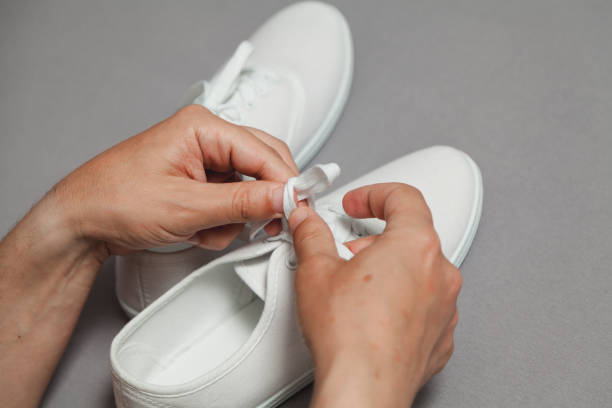 istock Hands tie  lace on new white sneaker 1164398467