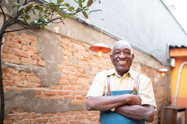 istock Portrait of smiling elderly waiter looking at camera 1164403641