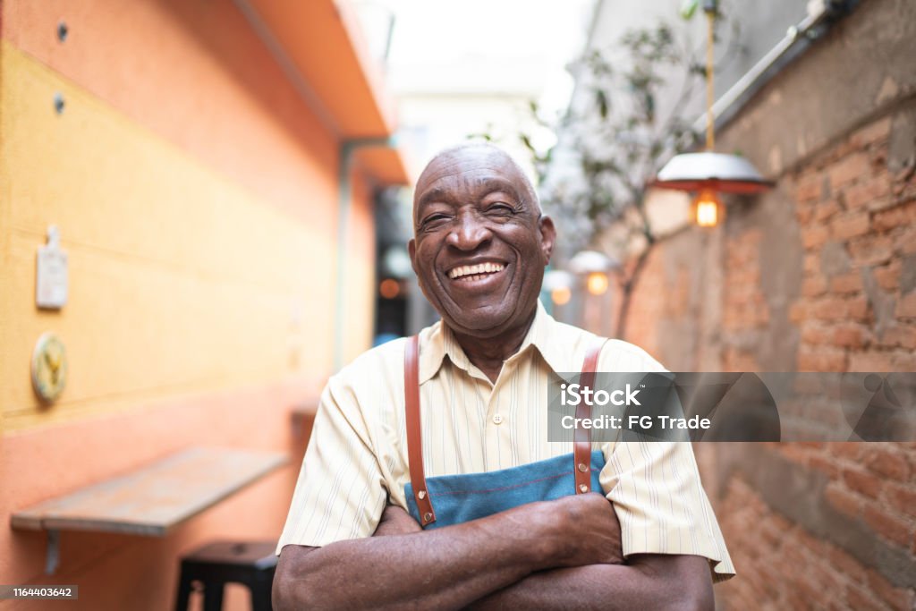 Portrait of smiling elderly waiter looking at camera Senior Adult Stock Photo