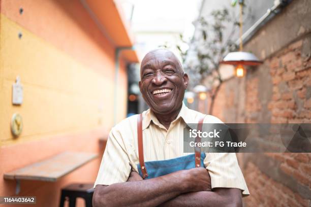 Portrait Of Smiling Elderly Waiter Looking At Camera Stock Photo - Download Image Now