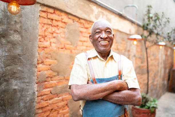 istock Portrait of smiling elderly waiter looking at camera 1164405130