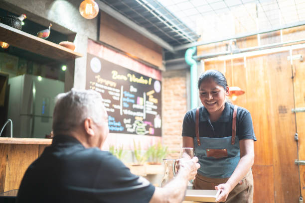 istock Waitress serving drink to a customer at restaurant 1164405198