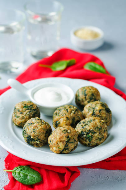 istock Cheese spinach balls with spinach leaves and greek yogurt sauce 1164405814
