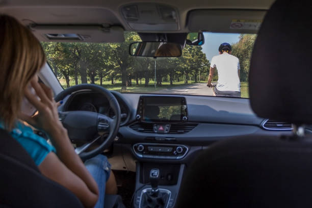 istock Woman driving a car while using mobile phone 1164407296