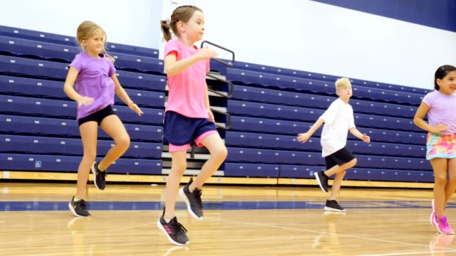 Elementary school students exercise during PE class