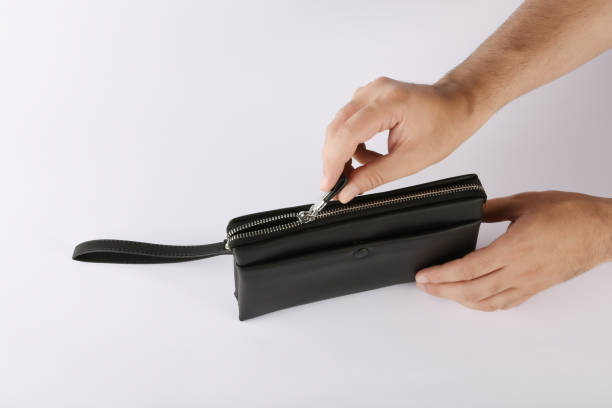 istock A male hand opening black leather bag isolated on white 1164412701