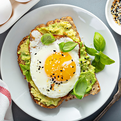 Avocado toast with fried sunny side up egg overhead view
