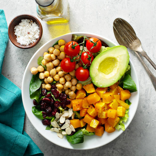 Vegan lunch bowl with chickpeas, avocado, vegetables, and roasted squash overhead