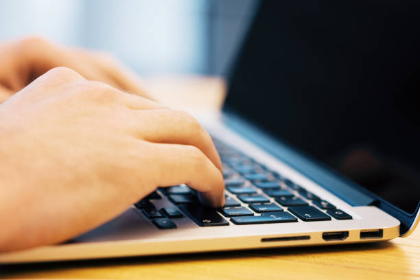 istock Sideview of male using laptop on desk 1164421259