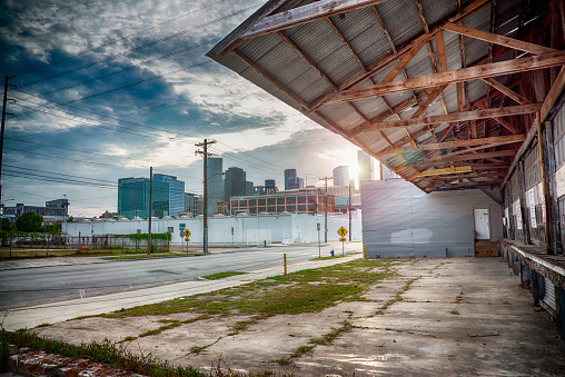 The loading docks of an abandoned industrial warehouse and manufacturing building located in the eastern end of the city of Houston, Texas, in the shadow of it's skyline symbolizing urban decay and an area in need of redevelopment.
