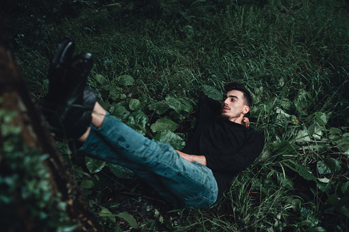A young handsome man lying down in nature