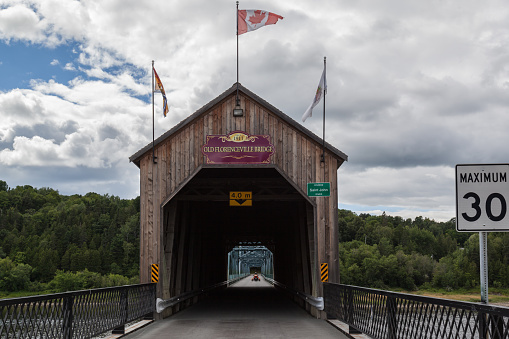 New Brunswick, Canada - August 6, 2017:Florenceville Bridge in New Brunswick, Canada. Built in 1907, this covered bridge is 46.9 m (154 ft.) in length.\nand combined with a steel trusses.