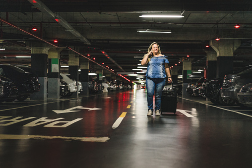 Smiling woman walking in underground car parking