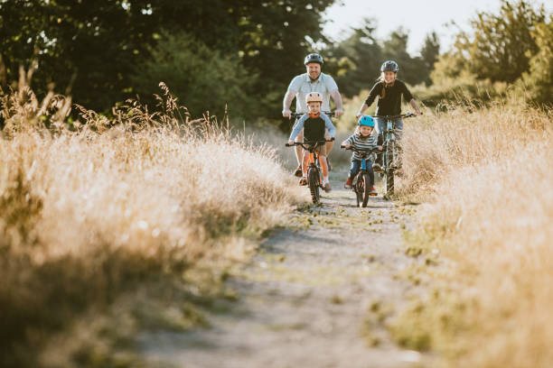 vélo de montagne de famille équitation ensemble le jour ensoleillé - family bicycle cycling healthy lifestyle photos et images de collection