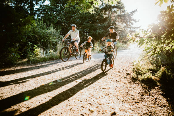 vélo de montagne de famille équitation ensemble le jour ensoleillé - activité de plein air photos et images de collection