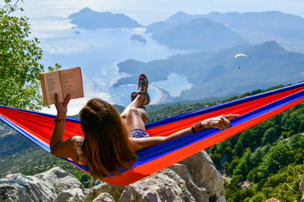 Woman relaxing in hammock by herself deep in forest.