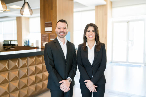 istock Happy Colleagues Wearing Suits In Lobby 1164434389
