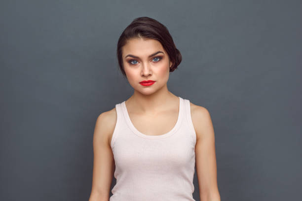 istock Freestyle. Woman standing isolated on grey looking camera concerned 1164435859