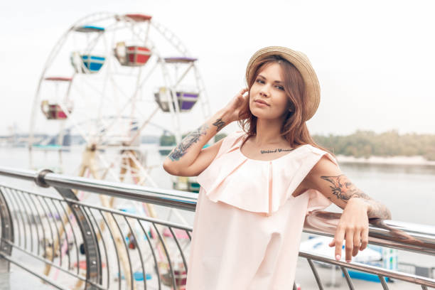 istock Ourdoors Leisure. Girl in hat standing on the bridge leaning back looking camera sensual 1164435904