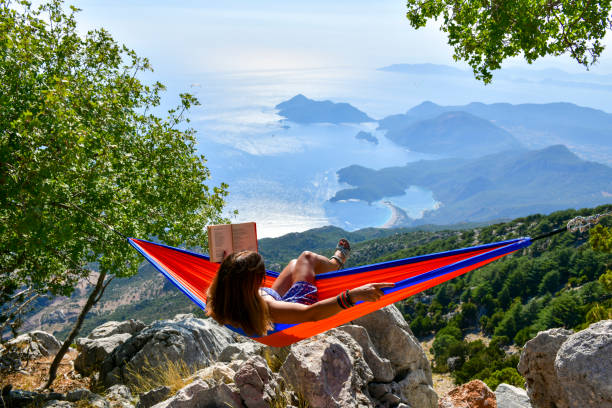 istock Woman studying book in hammock. 1164440652