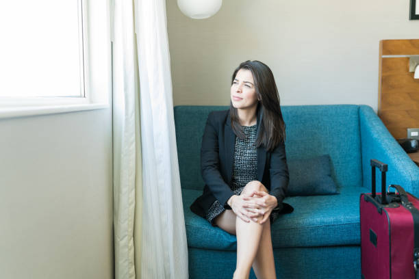 istock Businesswoman Thinking While Looking Through Window In Hotel Room 1164446160