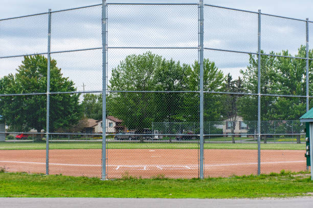 baseball oder softball-diamant durch einen zaun im park in einer kleinen kanadischen stadt brighton in der nähe von presquile lake provincial park - baseball diamond fotos stock-fotos und bilder