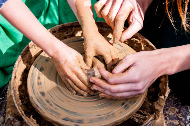istock Pottery training, four hands make a pot of clay 1164457242