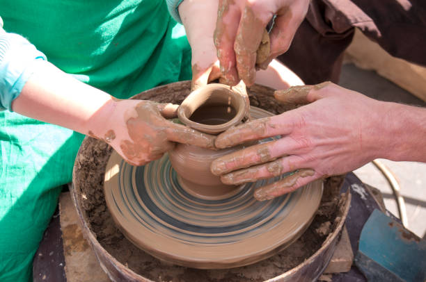 istock Pottery training, four hands make a pot of clay 1164457283