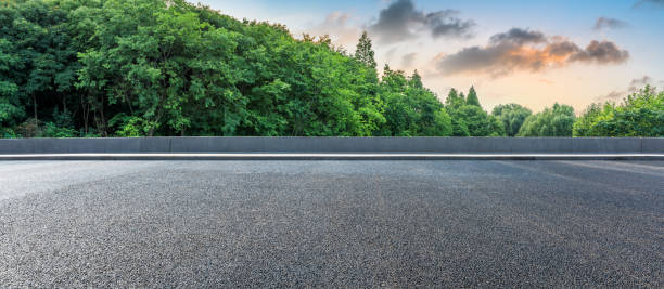 istock Asphalt highway and green forest with beautiful clouds landscape at sunset 1164460305
