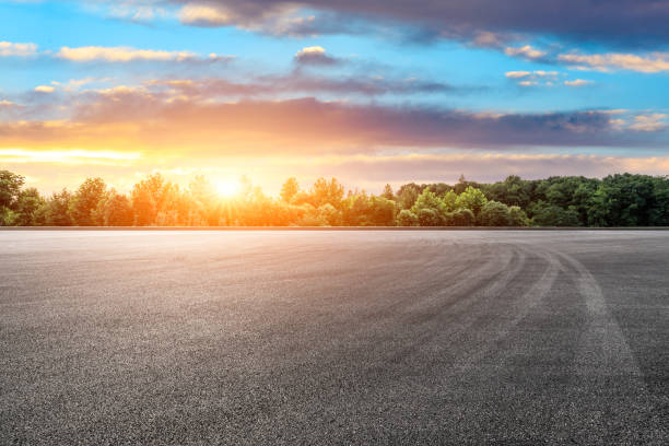 istock Empty race track and green forest with beautiful clouds at sunset 1164461075