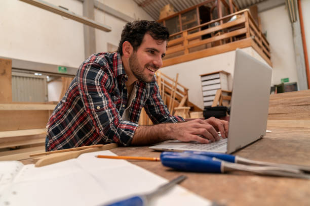 istock Happy man at a carpentry researching online for his DIY project 1164461124
