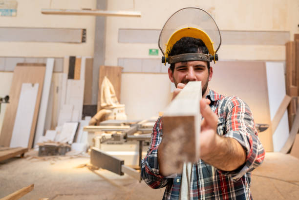 istock Carpenter working at the workshop and looking at a piece of wood 1164461172